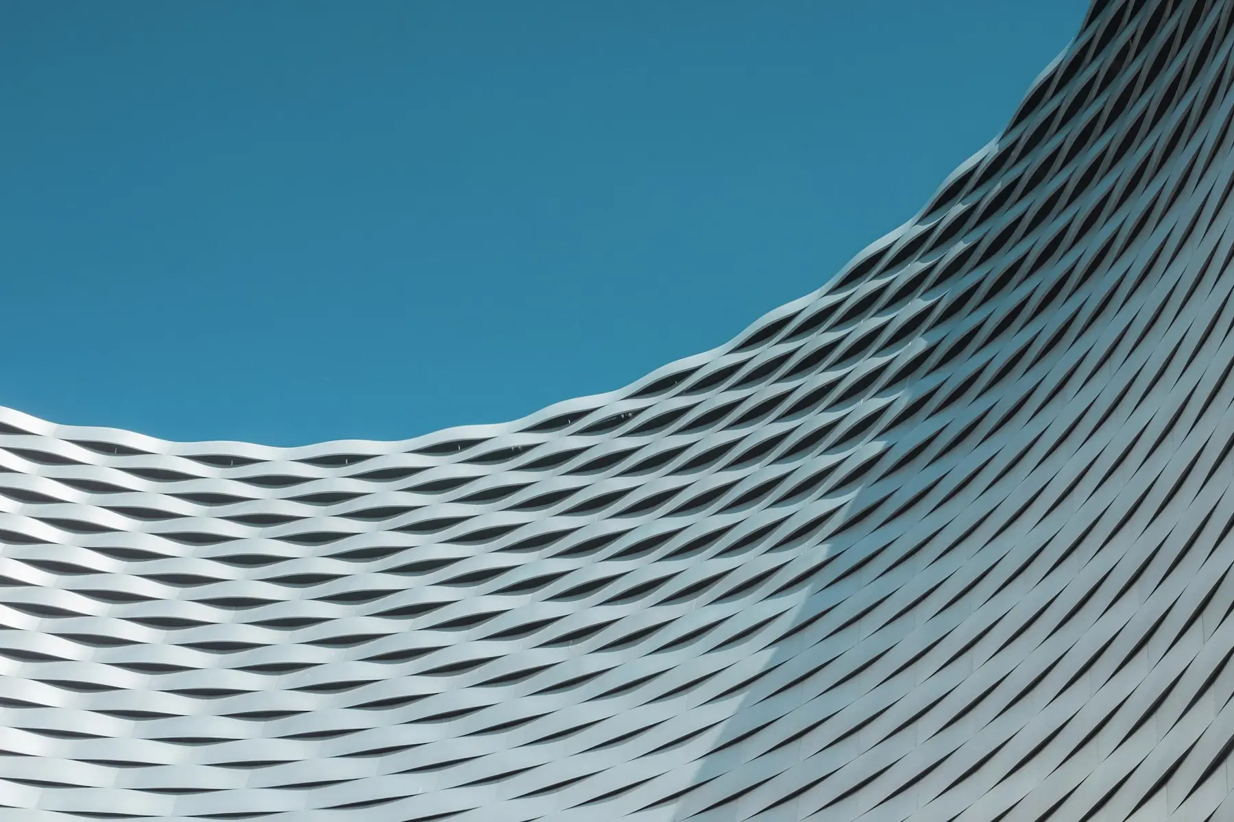 Geschwungenes Fassadendetail vor blauem Himmel